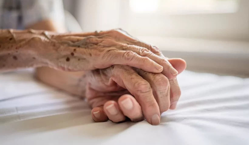 Main posée sur celle d'une personne âgée