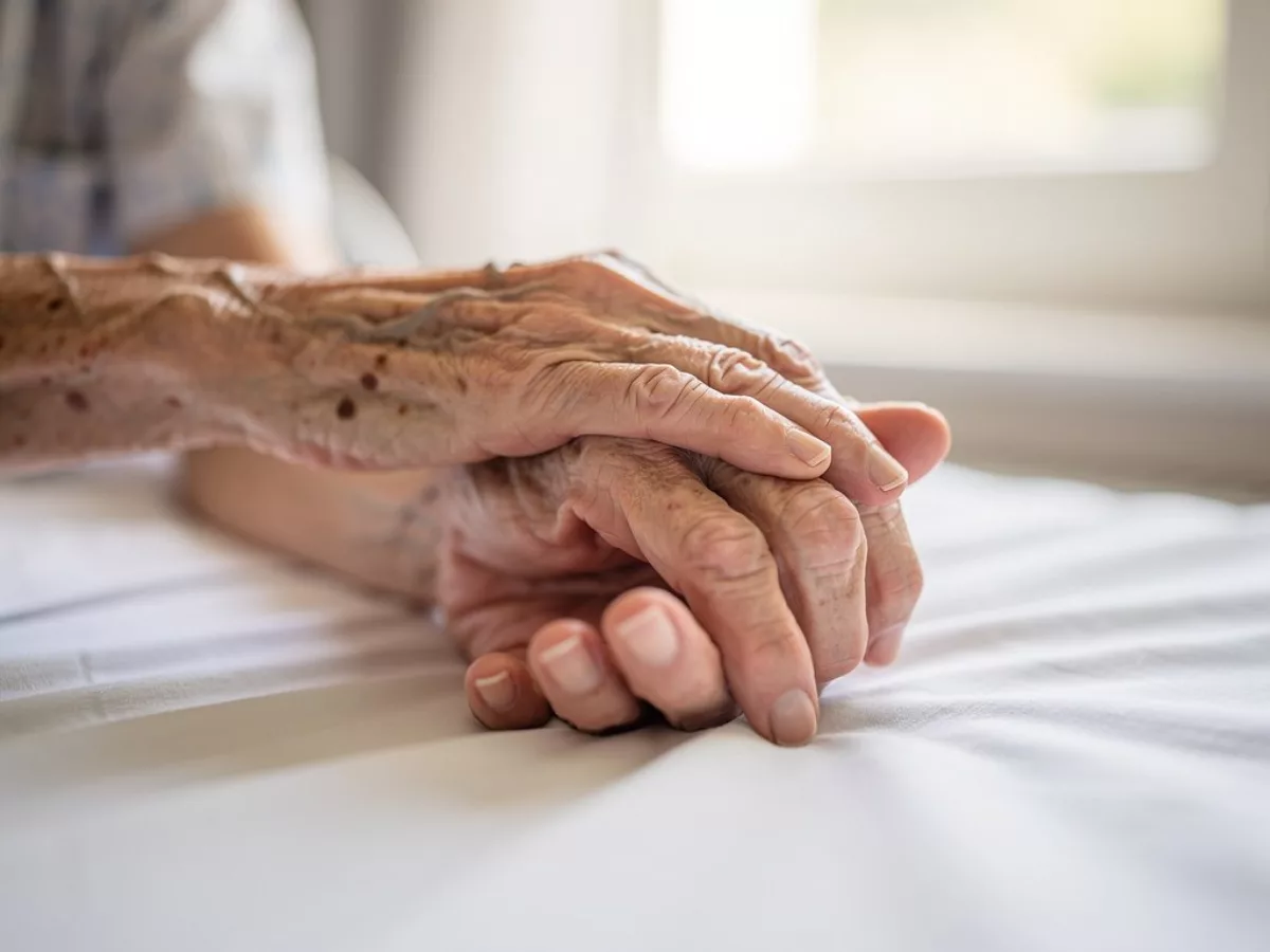 Main posée sur celle d'une personne âgée
