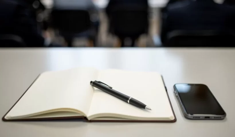Carnet, stylo et smartphone en conférence de presse