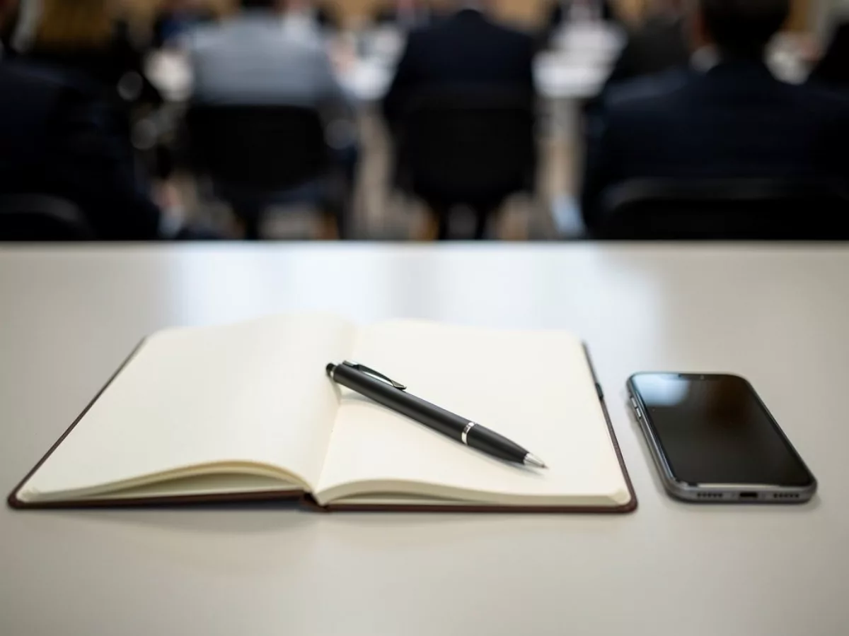 Carnet, stylo et smartphone en conférence de presse